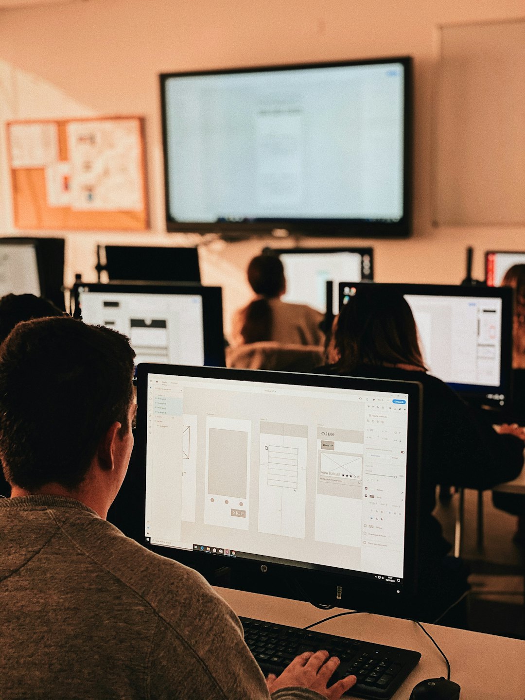 Personne travaillant sur un logiciel de conception UI/UX sur un ordinateur.